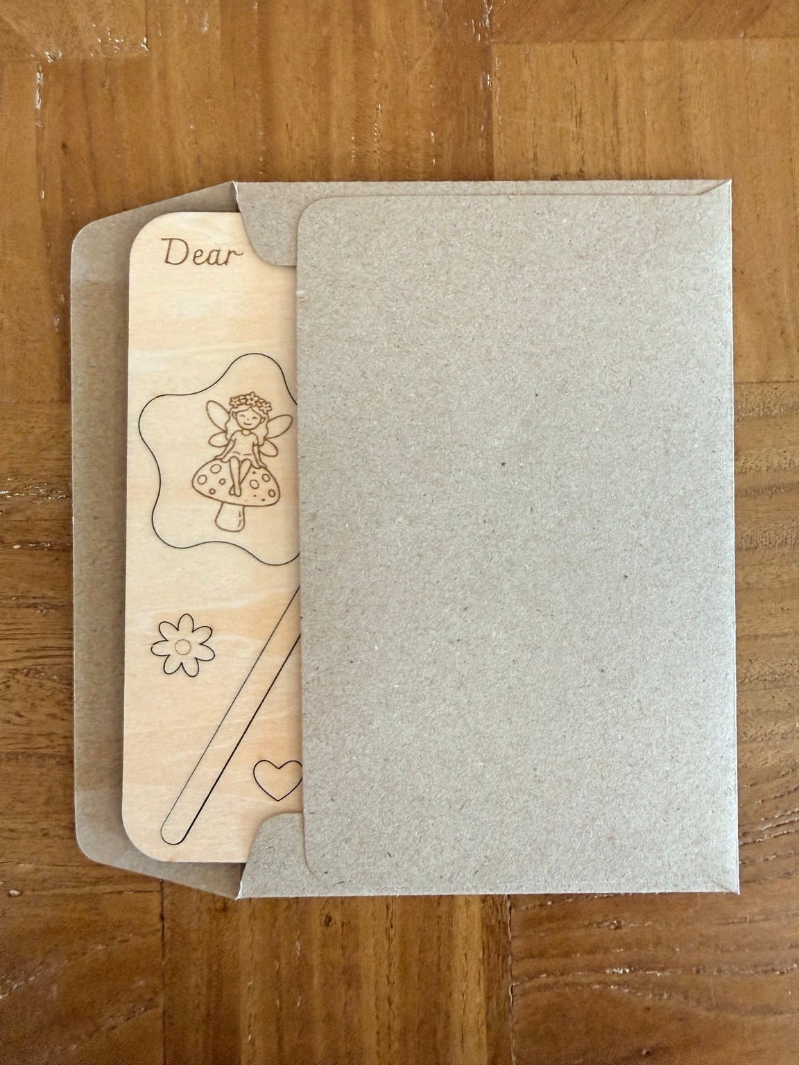 Wooden fairy wand birthday card tucked into its recycled brown paper envelope